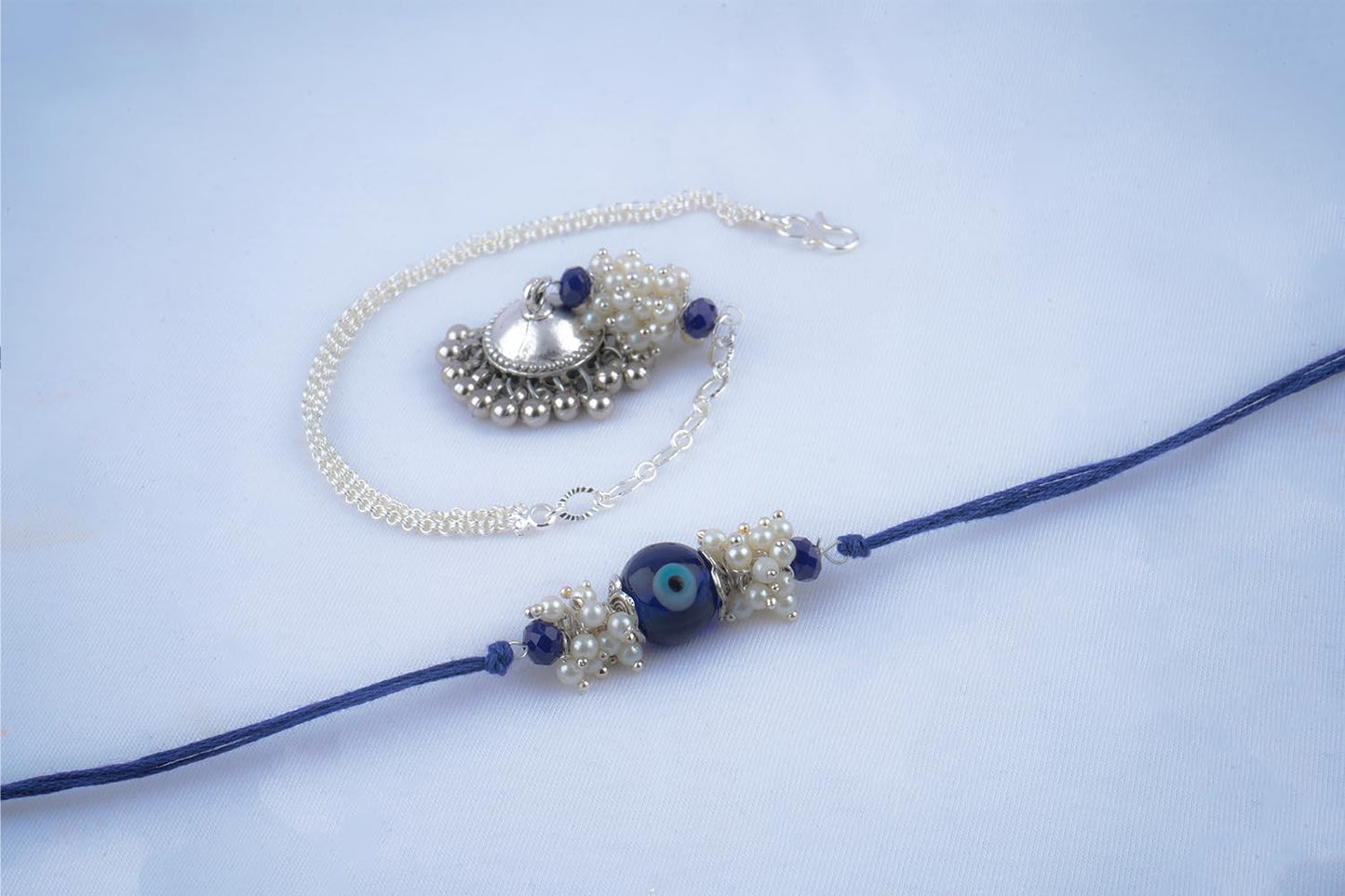 Forless Handmade Rakhi Combo Couple Pair Blue Evil Eye Rakhi And Silver Plated Jhumki Pearl Bracelet For Bhaiya Bhabhi With Roli Chawal And Written Greeting Note