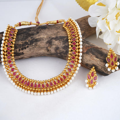 Gold Plated Necklace Set Studded With Ruby Red Stones And Embelished With Pearls.